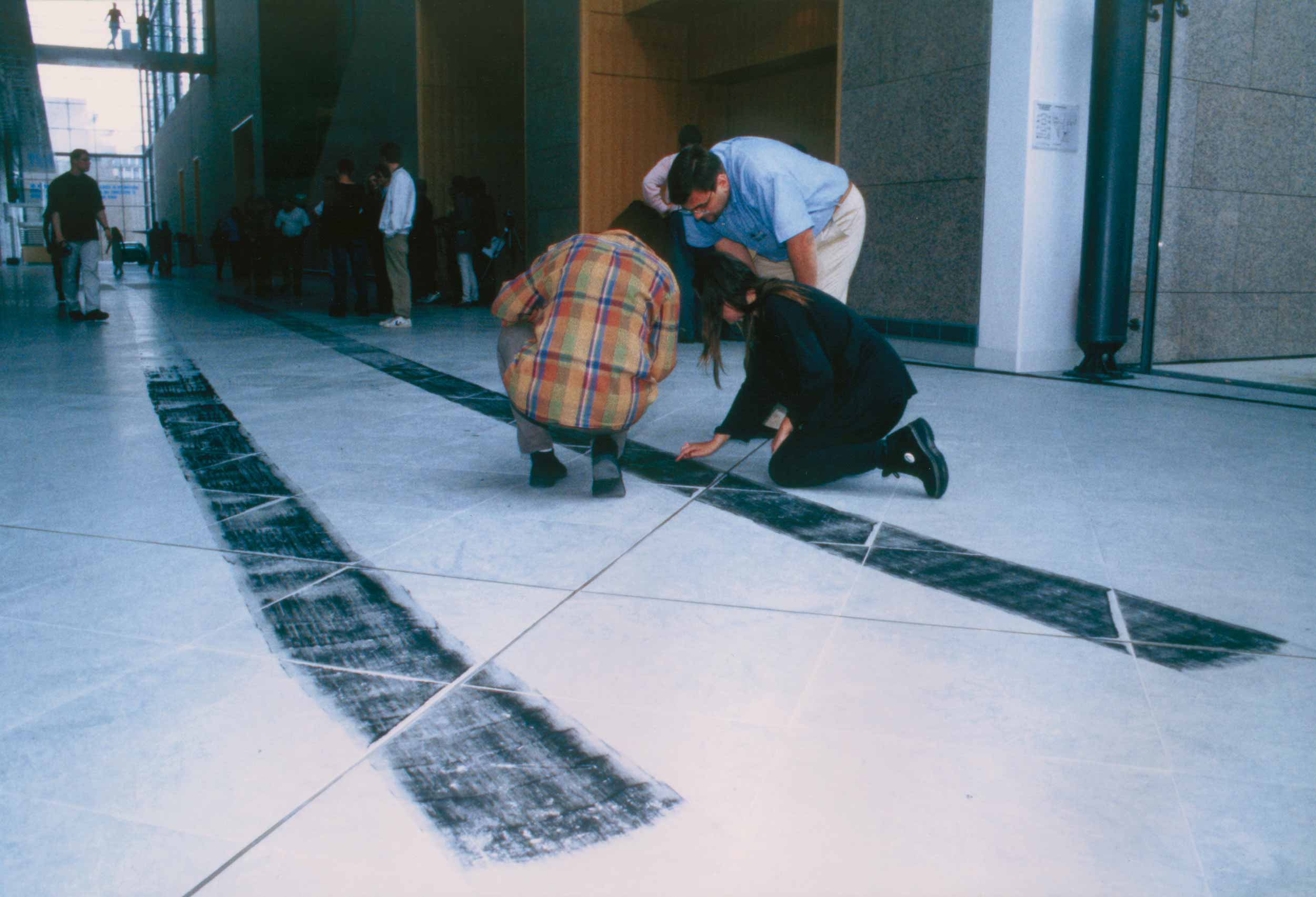 Car Track Installation: artists inspecting car tire tracks