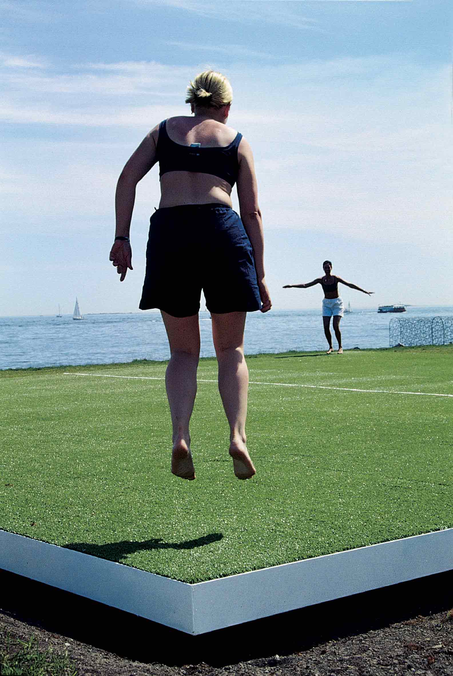 Jumping Field: two people jumping on installation