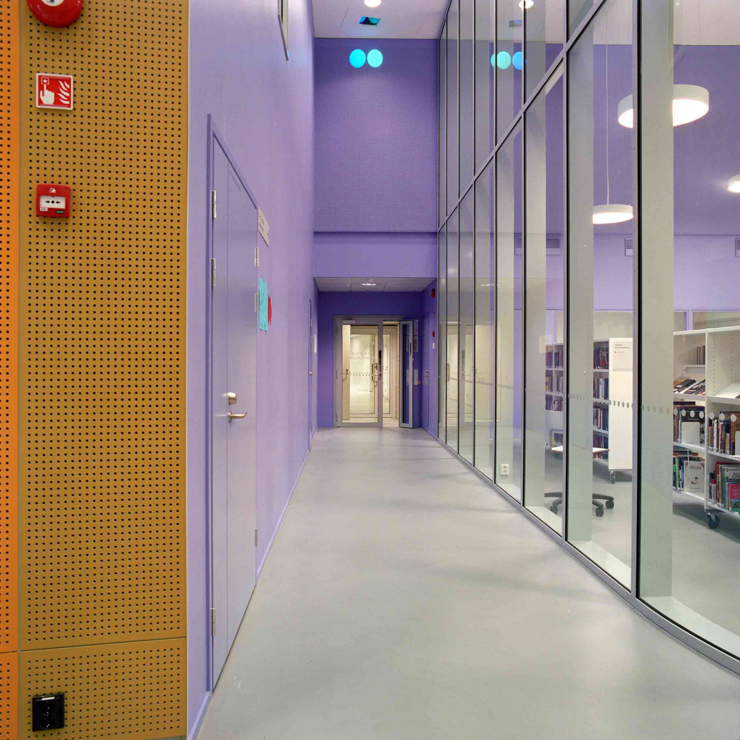 Pair of blue and cyan spots on a purple wall close to ceiling of a narrow hall