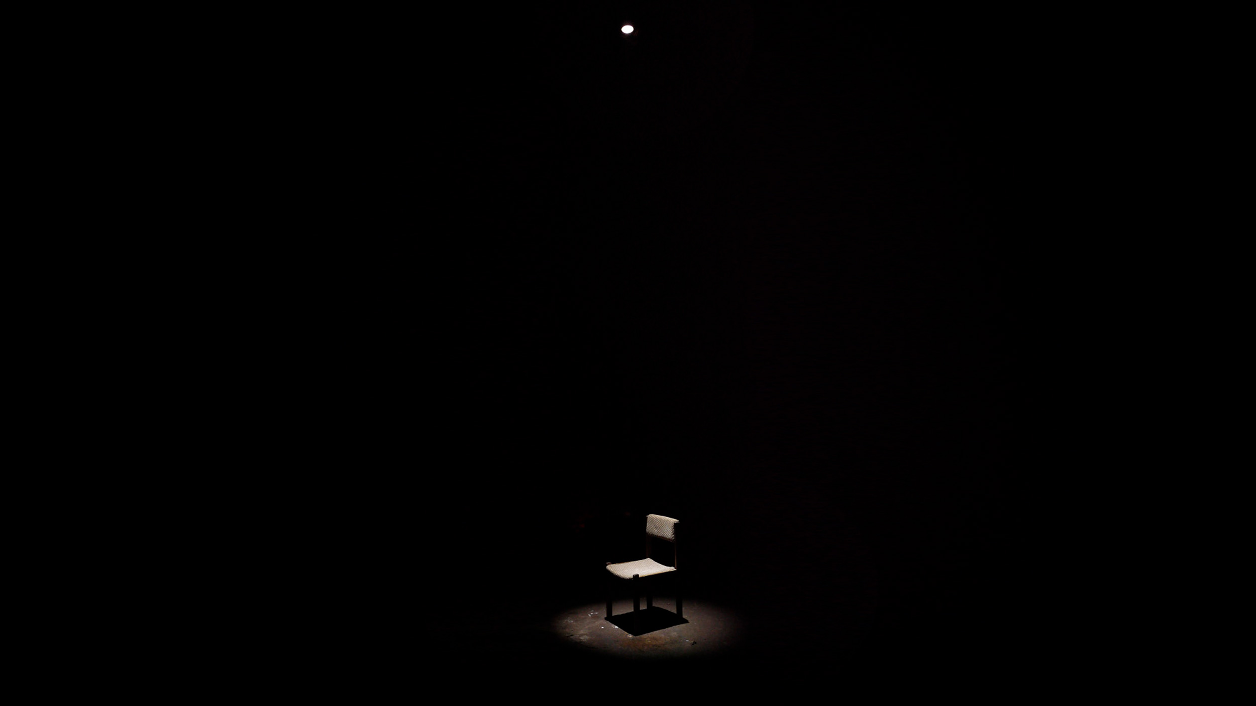 Chair with spotlight from top in the black exhibition space
