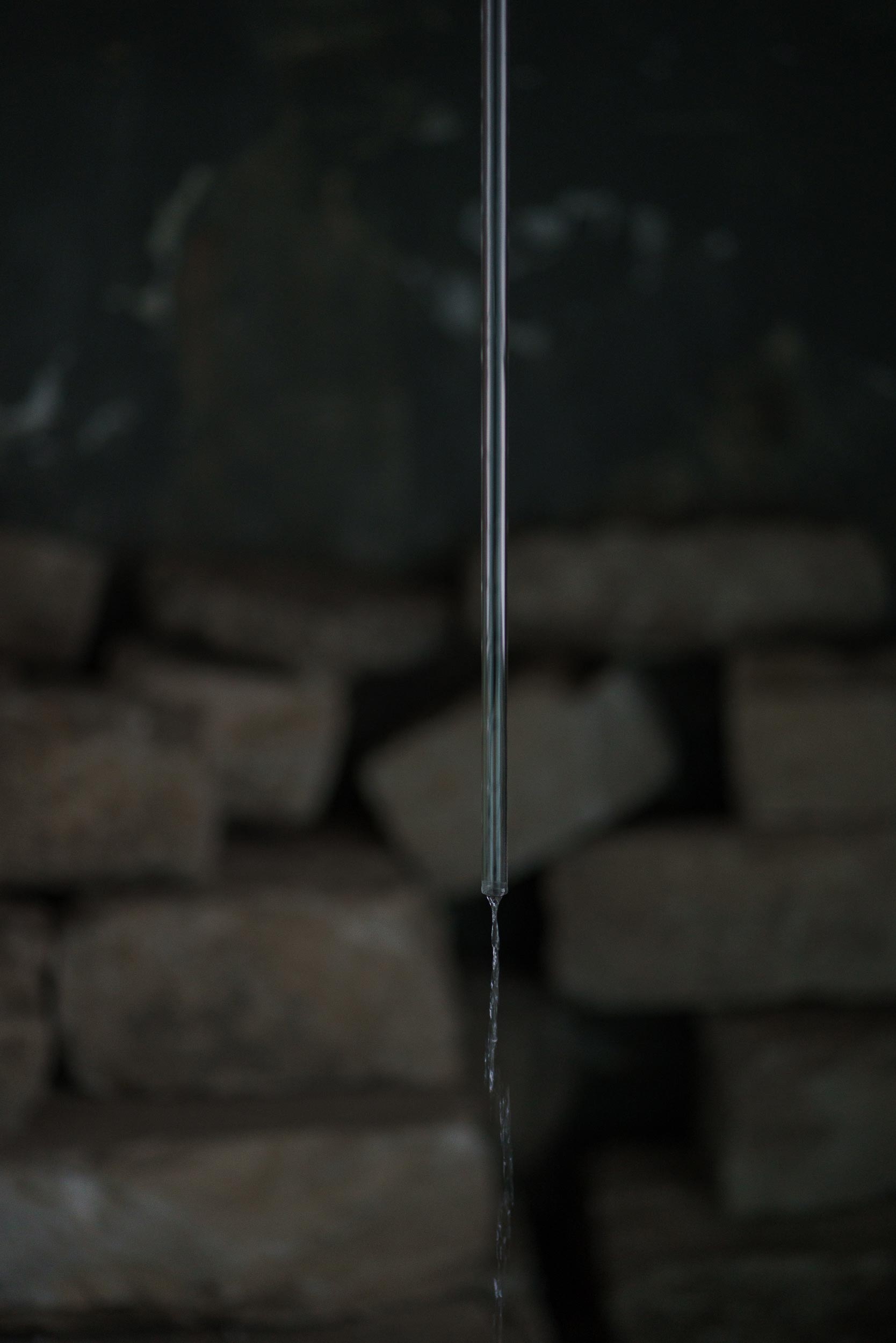 Imminence: close-up of water dripping from glass tube