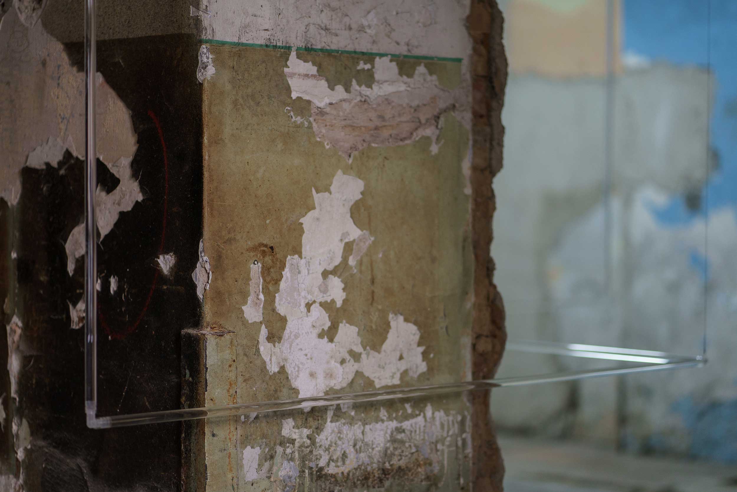 Imminence: close-up of glass tubes aligned around corner of wall