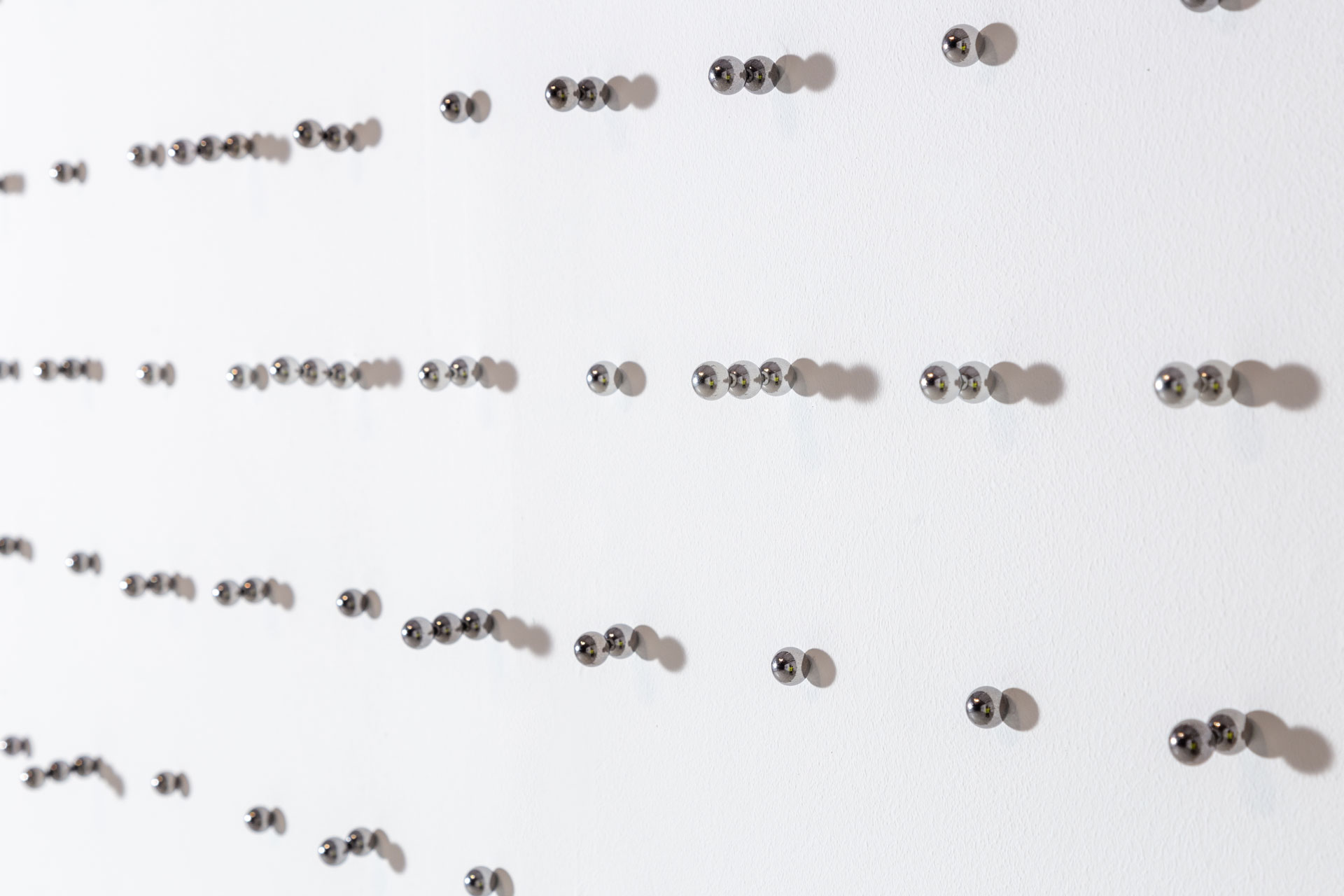 Arranged Randomness; close-up of steel balls stuck on wall