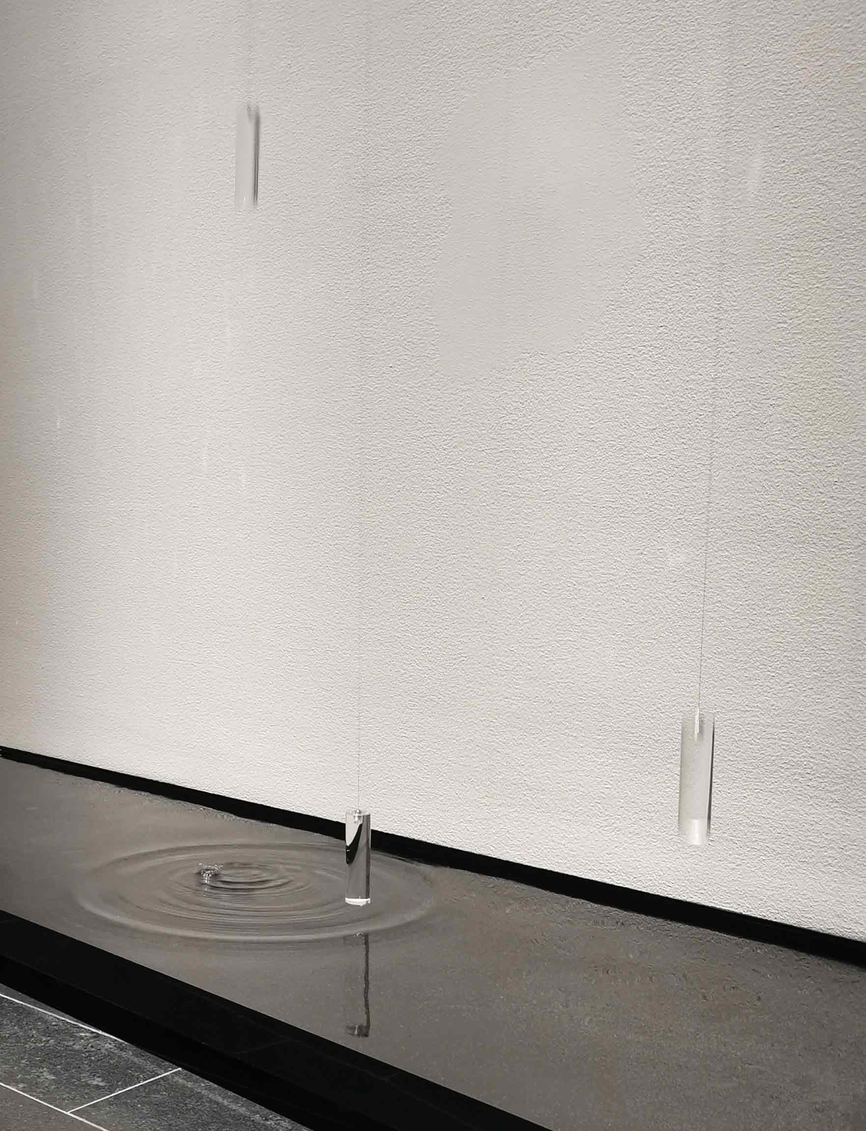 Acrylic counter weights dropping into pool of water causing ripples