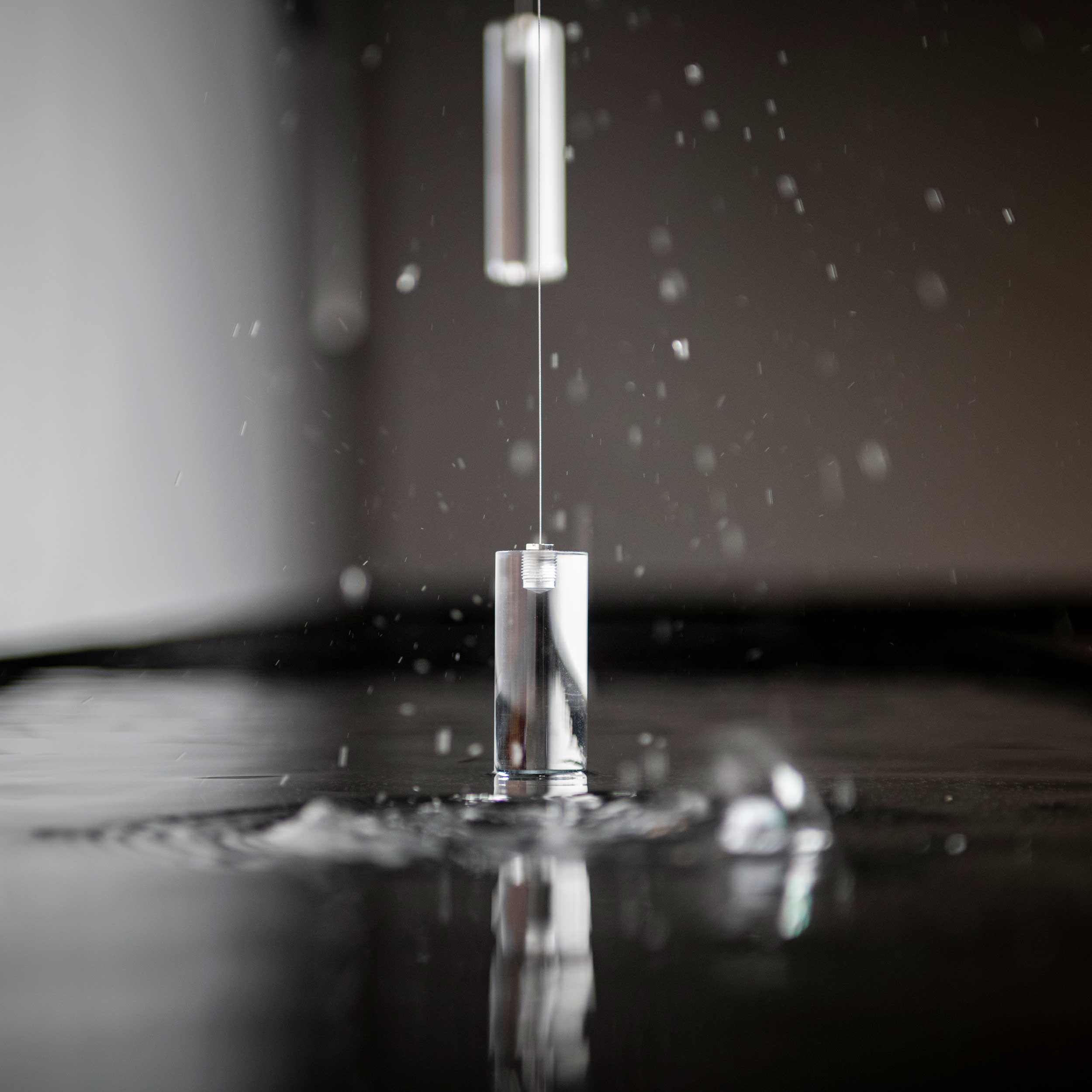 Close-up of acrylic counter weights at the moment of impact on the water surface
